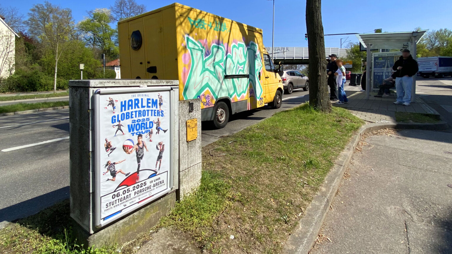 Werbung der Harlem Globetrotters auf einem Schaltkasten an einer belebten Busshaltestelle in Ludwigsburg